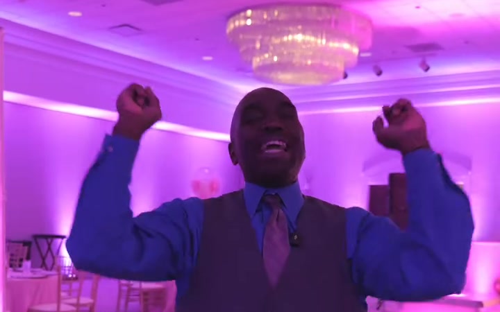 ATG MC cheering with fists raised under pink uplighting