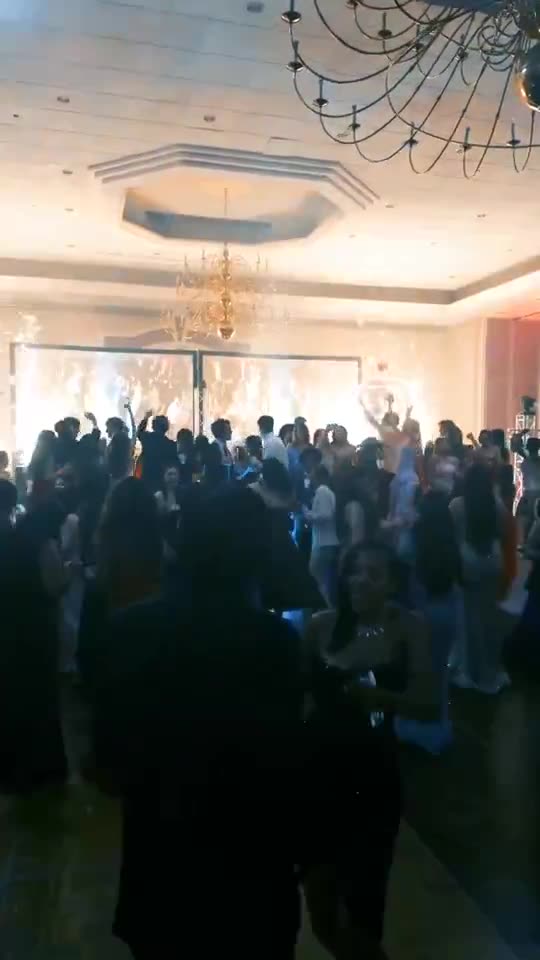 Crowd dancing in a chandelier ballroom at Le Méridien Charlotte