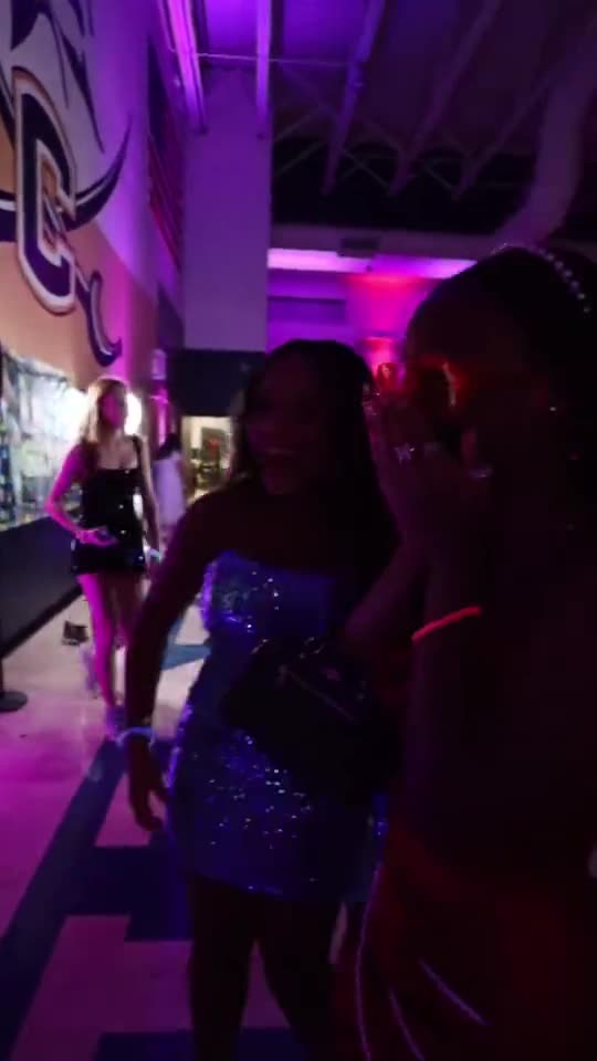 Students dancing in purple light at a homecoming dance