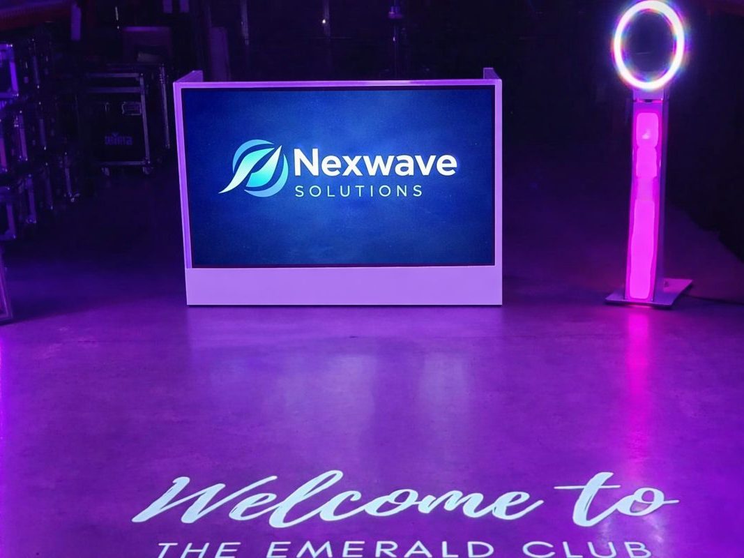 Video screen DJ booth showing a company logo on its large screen