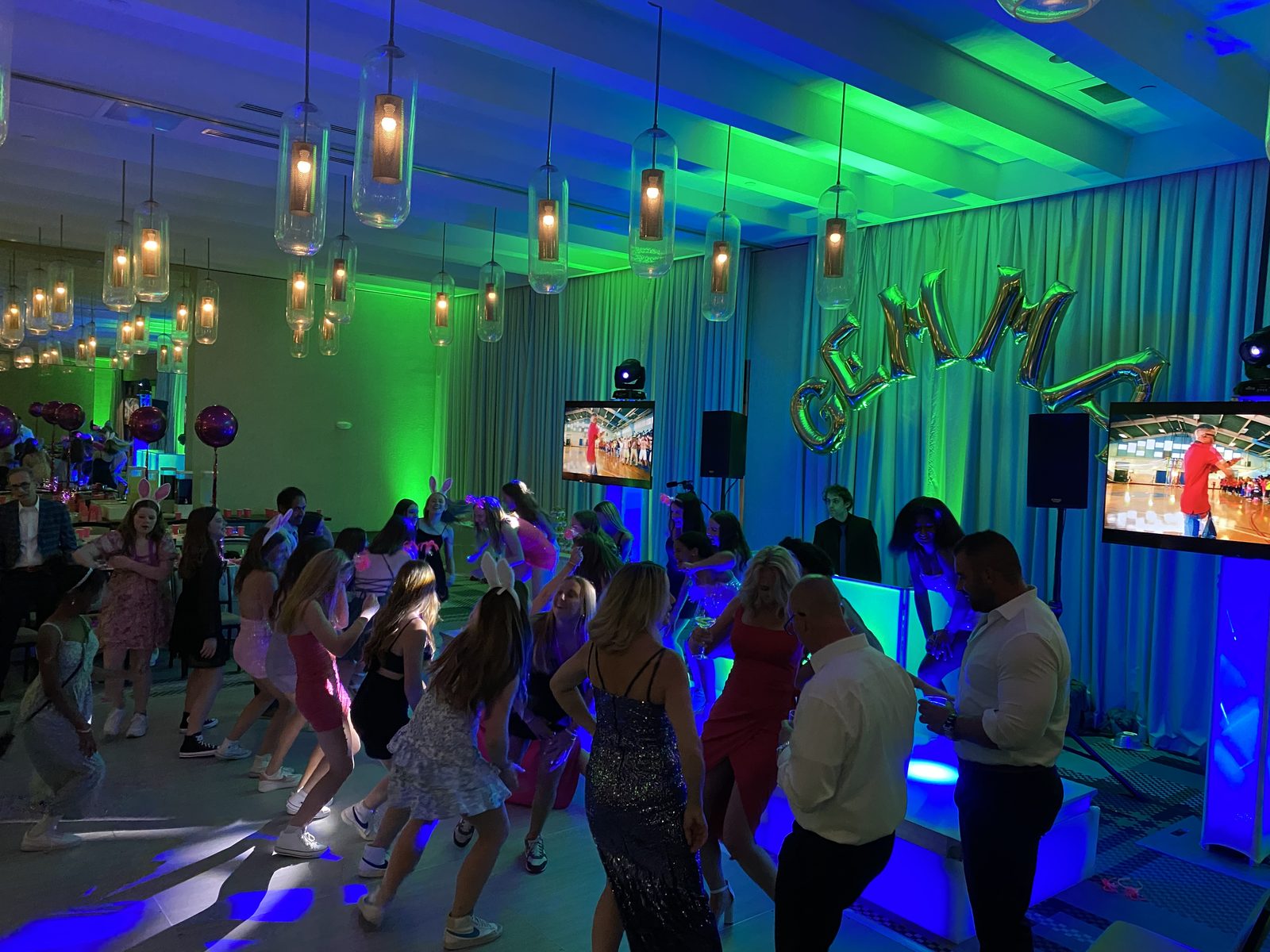 Bat Mitzvah dance floor with green and blue uplighting and TV screens