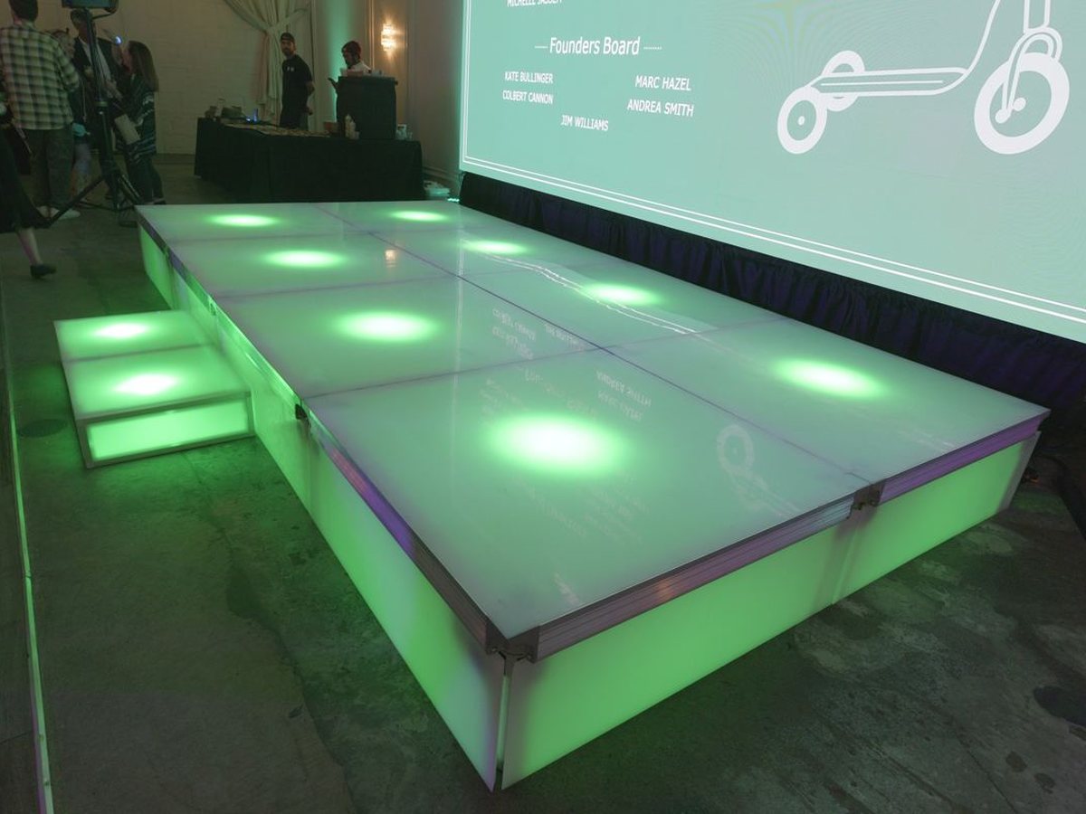 Lit LED stage platform with steps in front of a projection screen