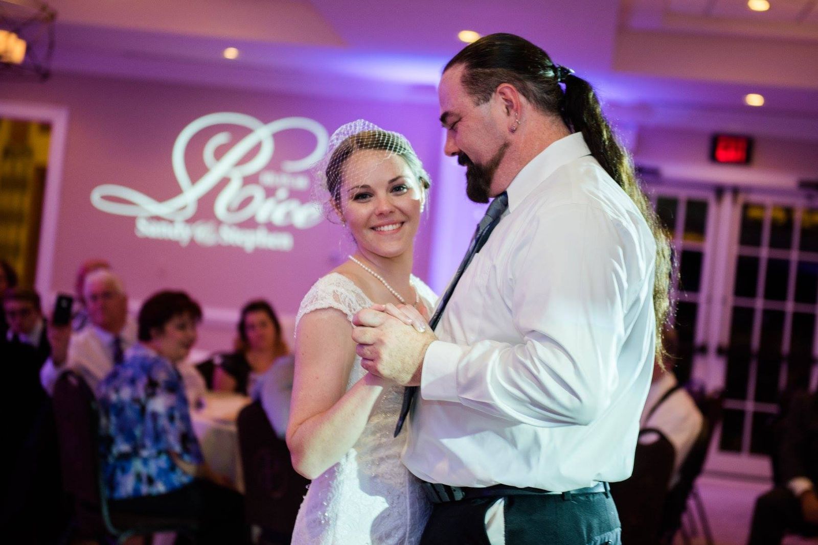 Couple dancing in front of a custom monogram projected on the wall